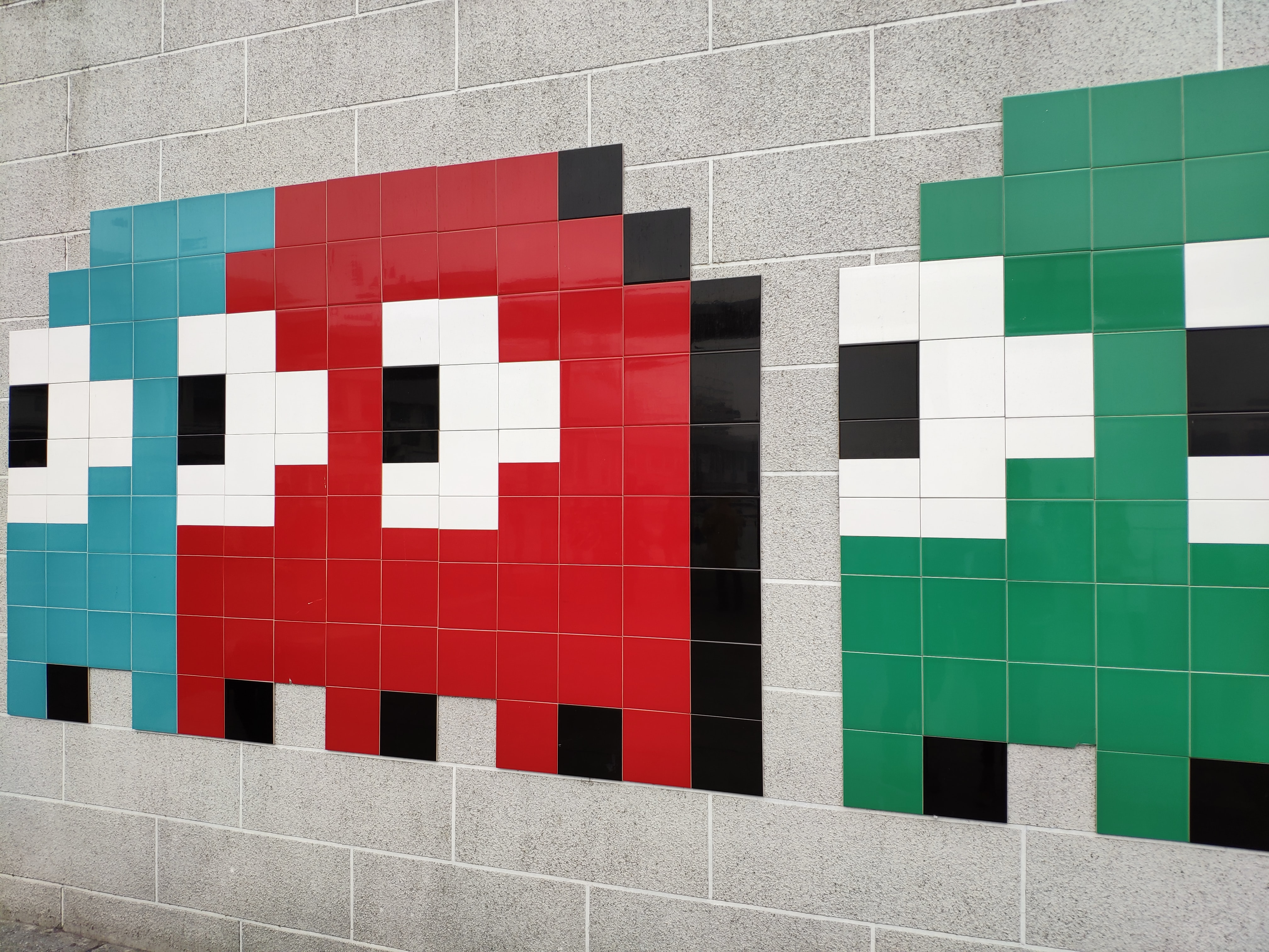 Die Geister aus Pac-Man an einer Wand.