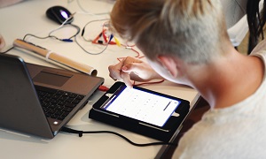 Schüler lernt mit Tablet und Computer