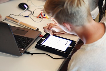 Schüler lernt mit Tablet und Computer
