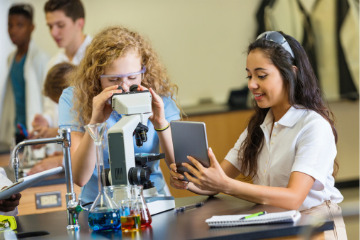 High school-Schüler mit digitalen tablet und Mikroskop in class